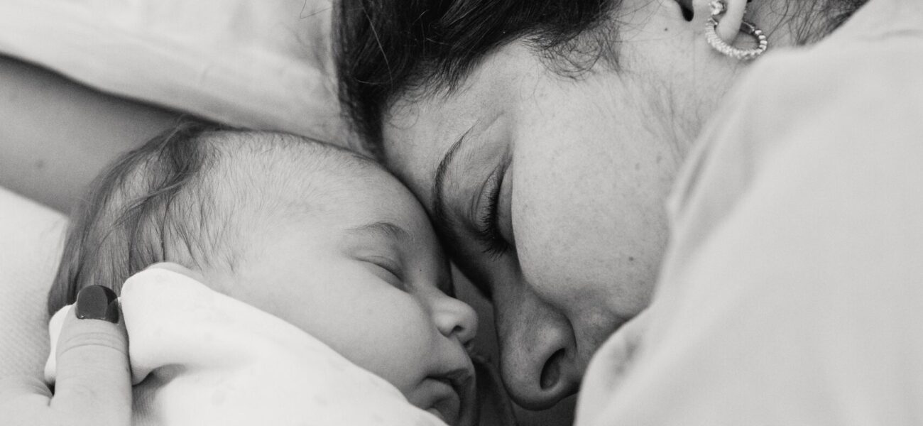 una foto en blanco y negro de una persona acostada en una cama con su hijo
